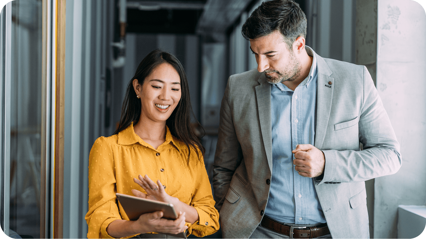 Image of a man and woman talking while looking at an iPad